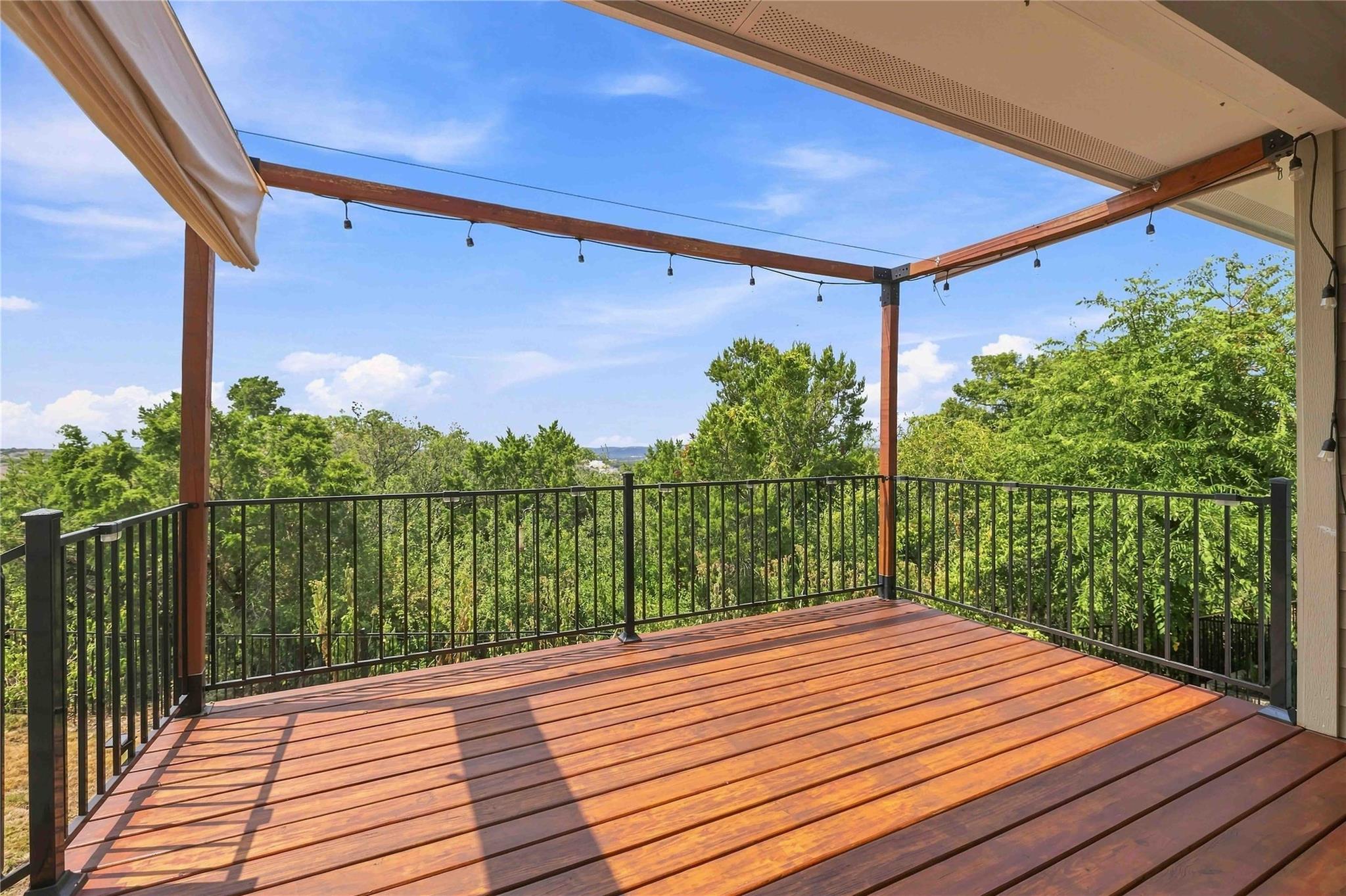 A spacious elevated wood deck looks out over lush