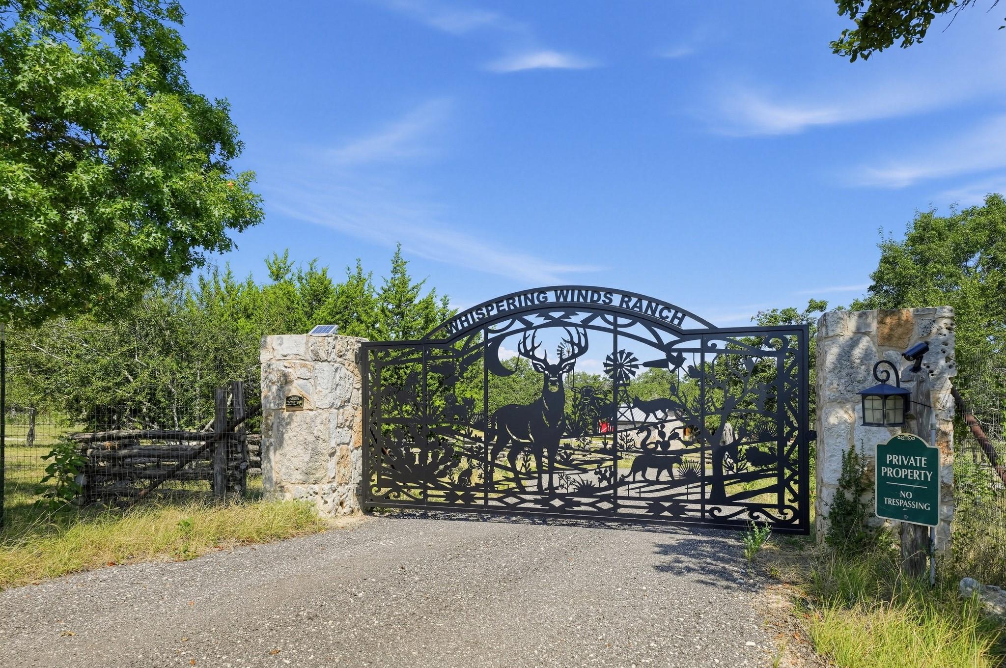 An ornate custom iron gate flanked by stone pilla