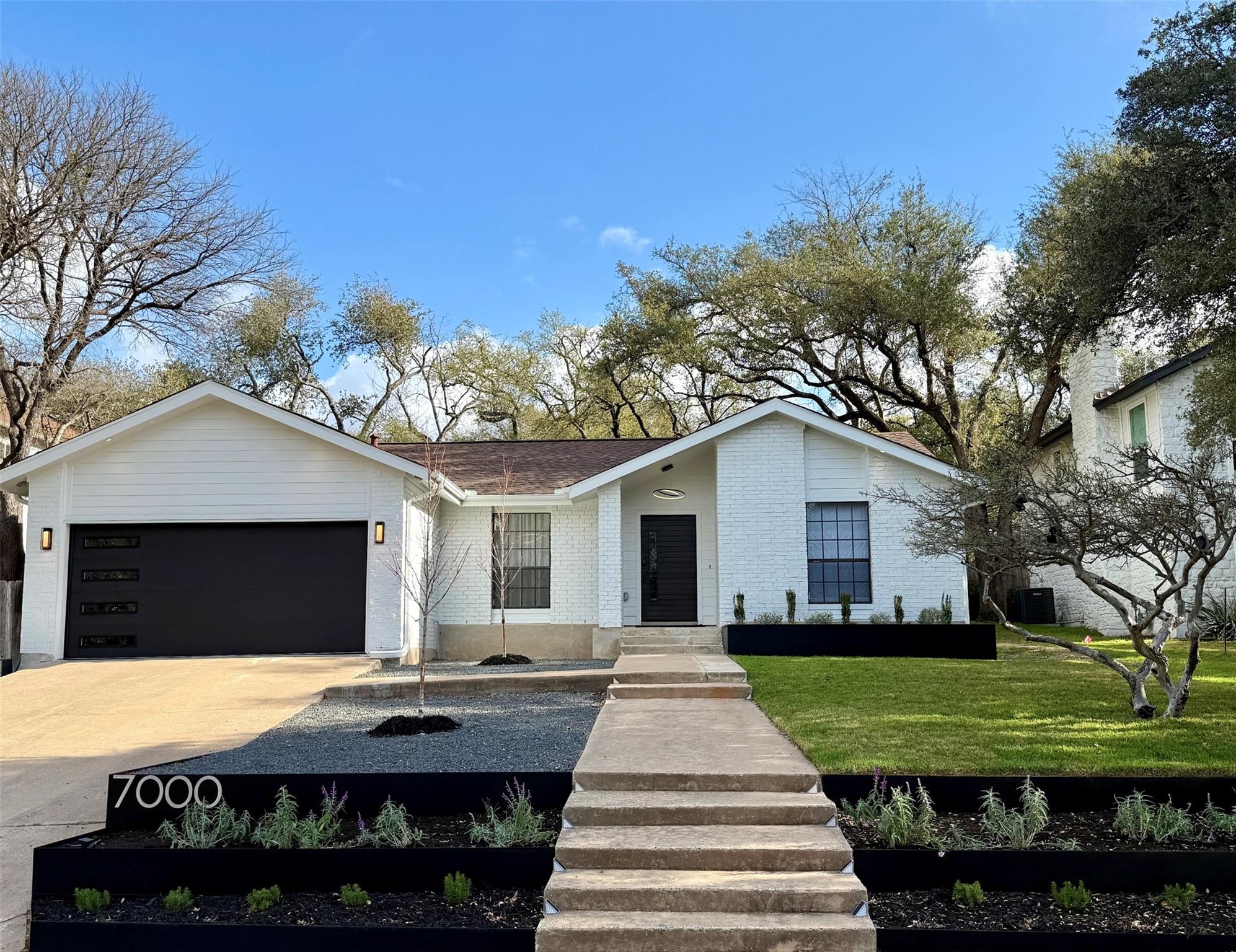 A concrete walkway leads up to a modern white bri
