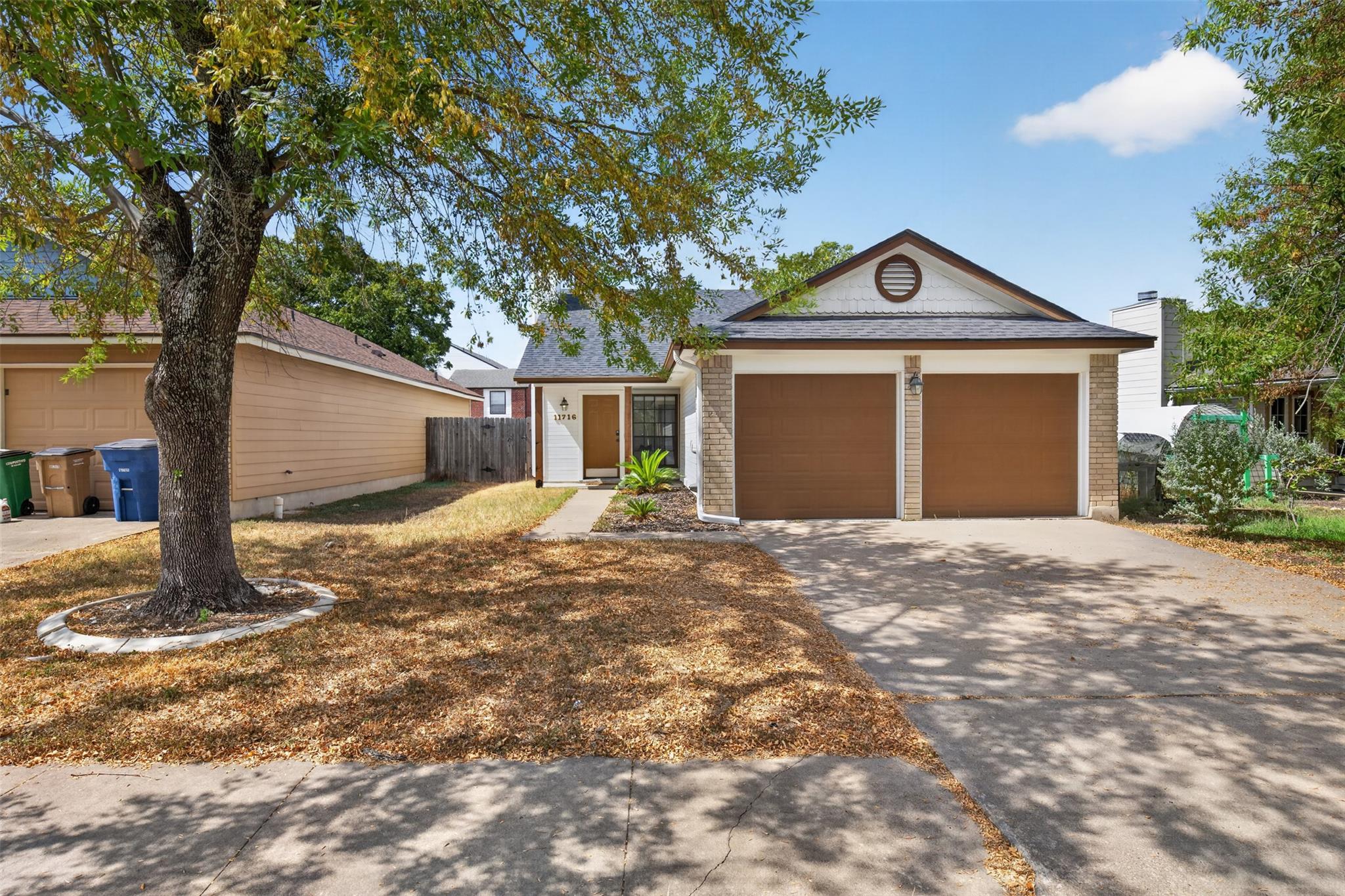Mature trees shade the front lawn and concrete dr