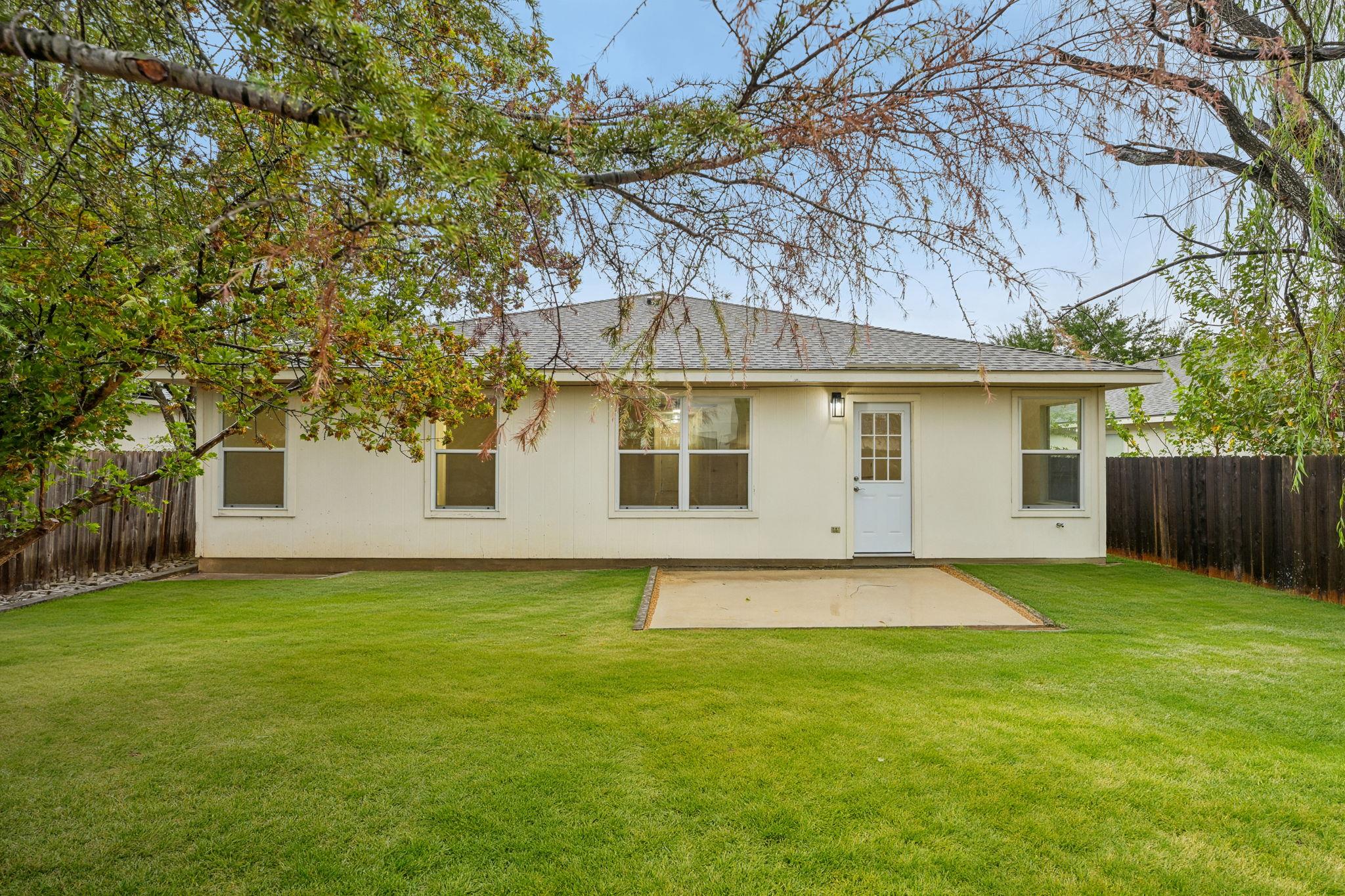 Mature trees frame a spacious, fully fenced lawn 