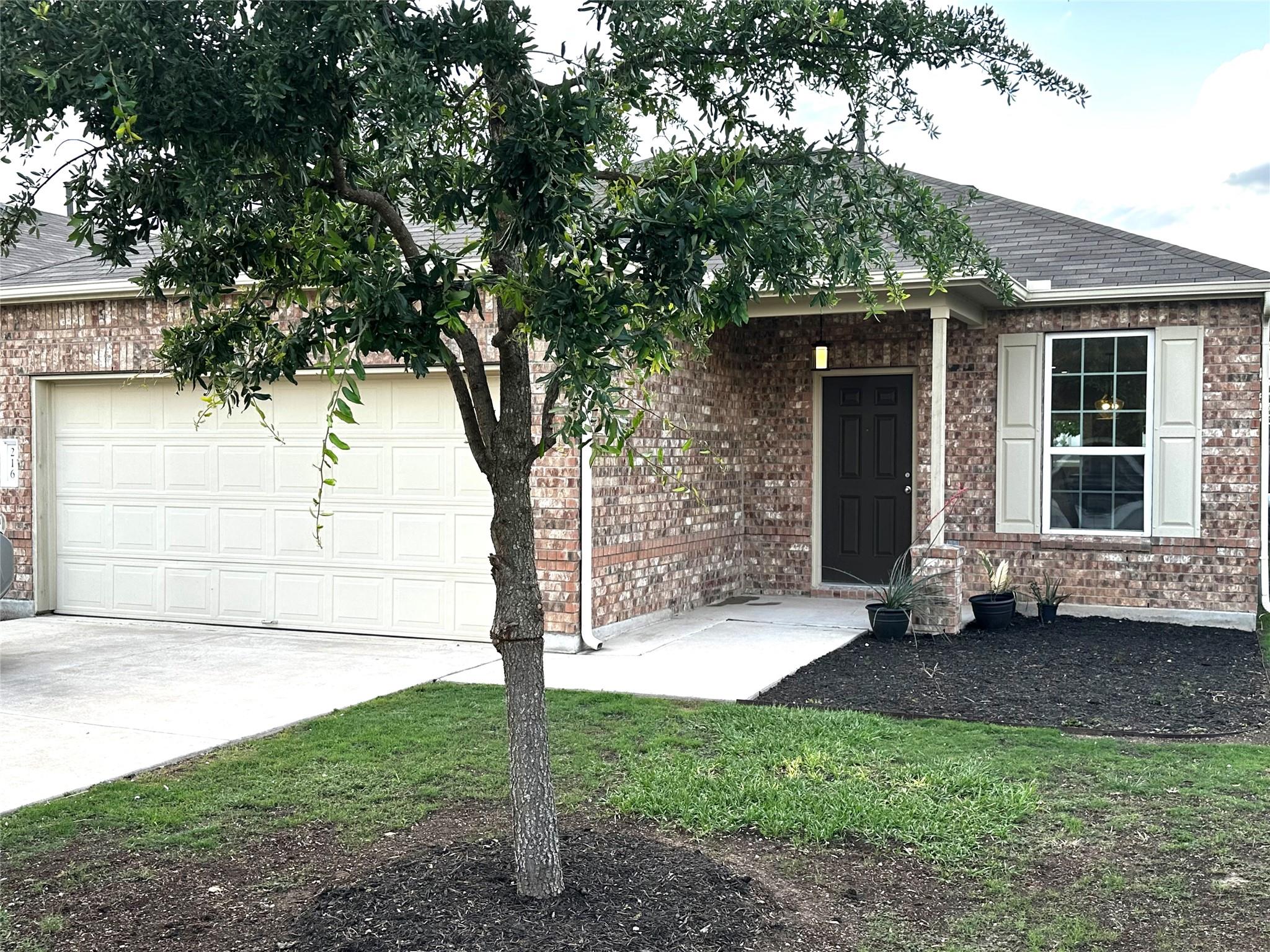 View of front of home featuring brick siding, dri