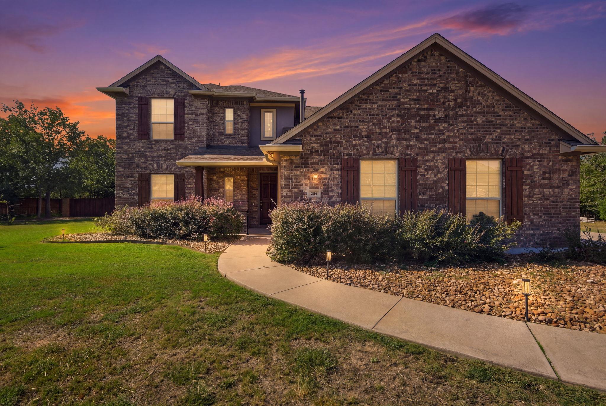 Warm exterior lighting accents the brick facade a