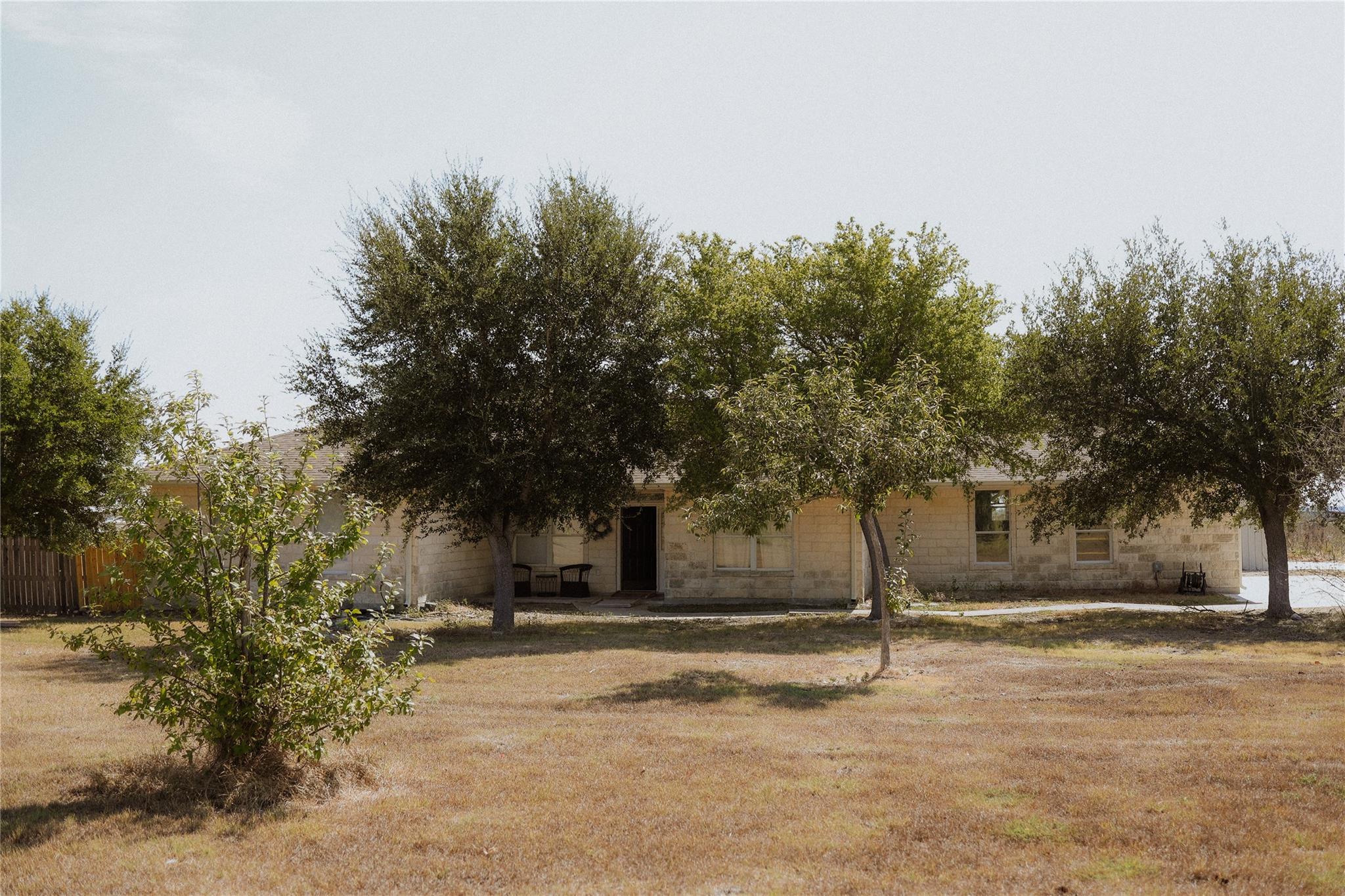 Mature trees shade a classic limestone home set o