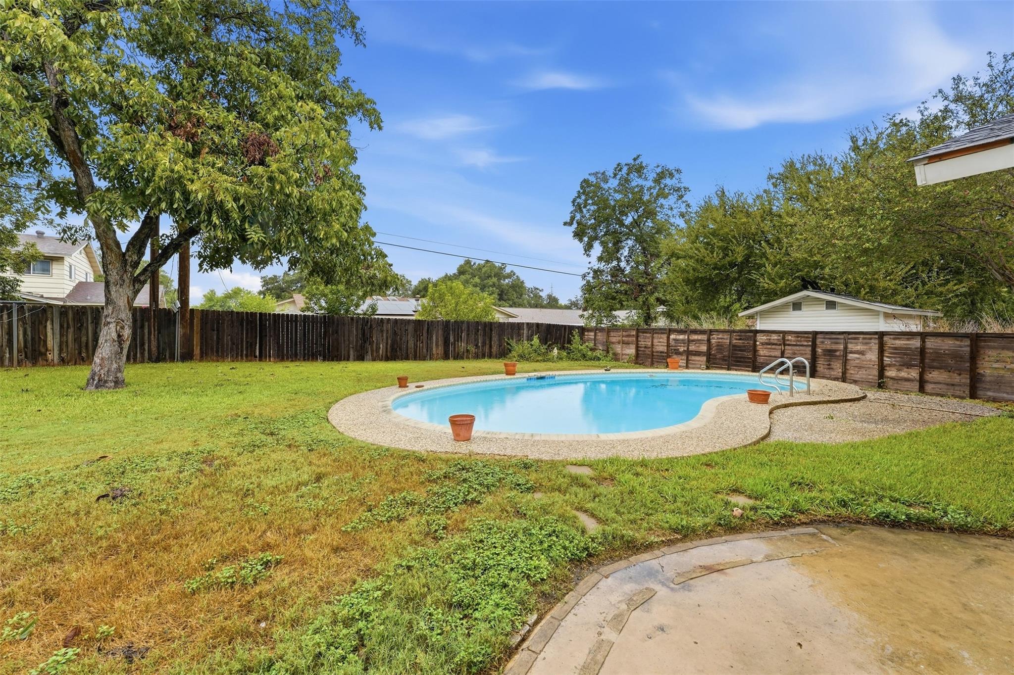 Mature trees frame a private swimming pool enclos