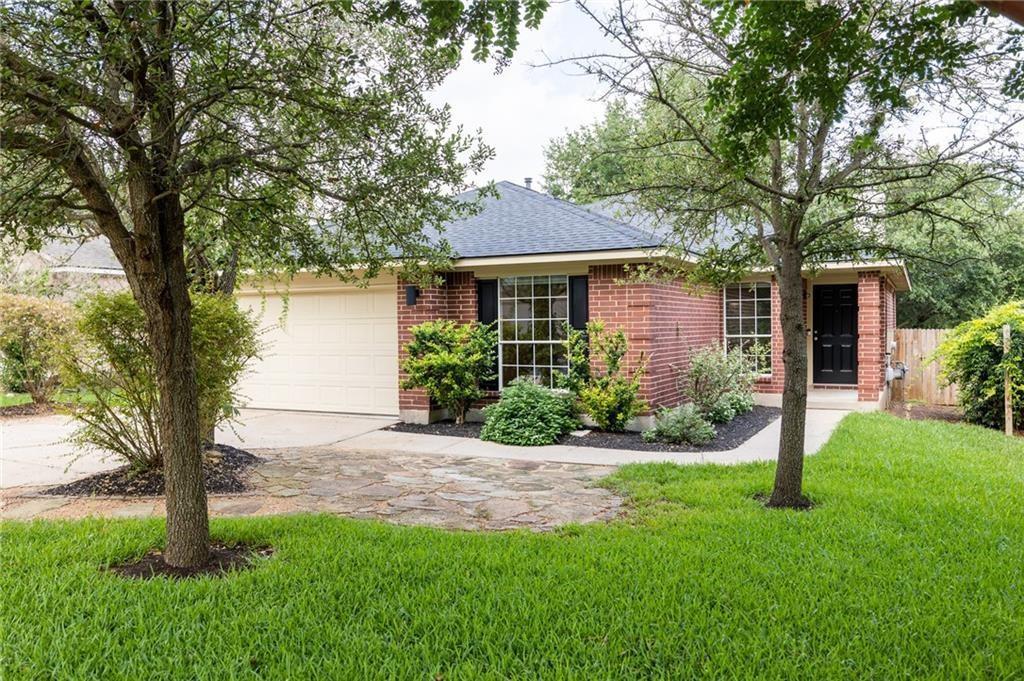 Mature trees shade a classic brick exterior compl