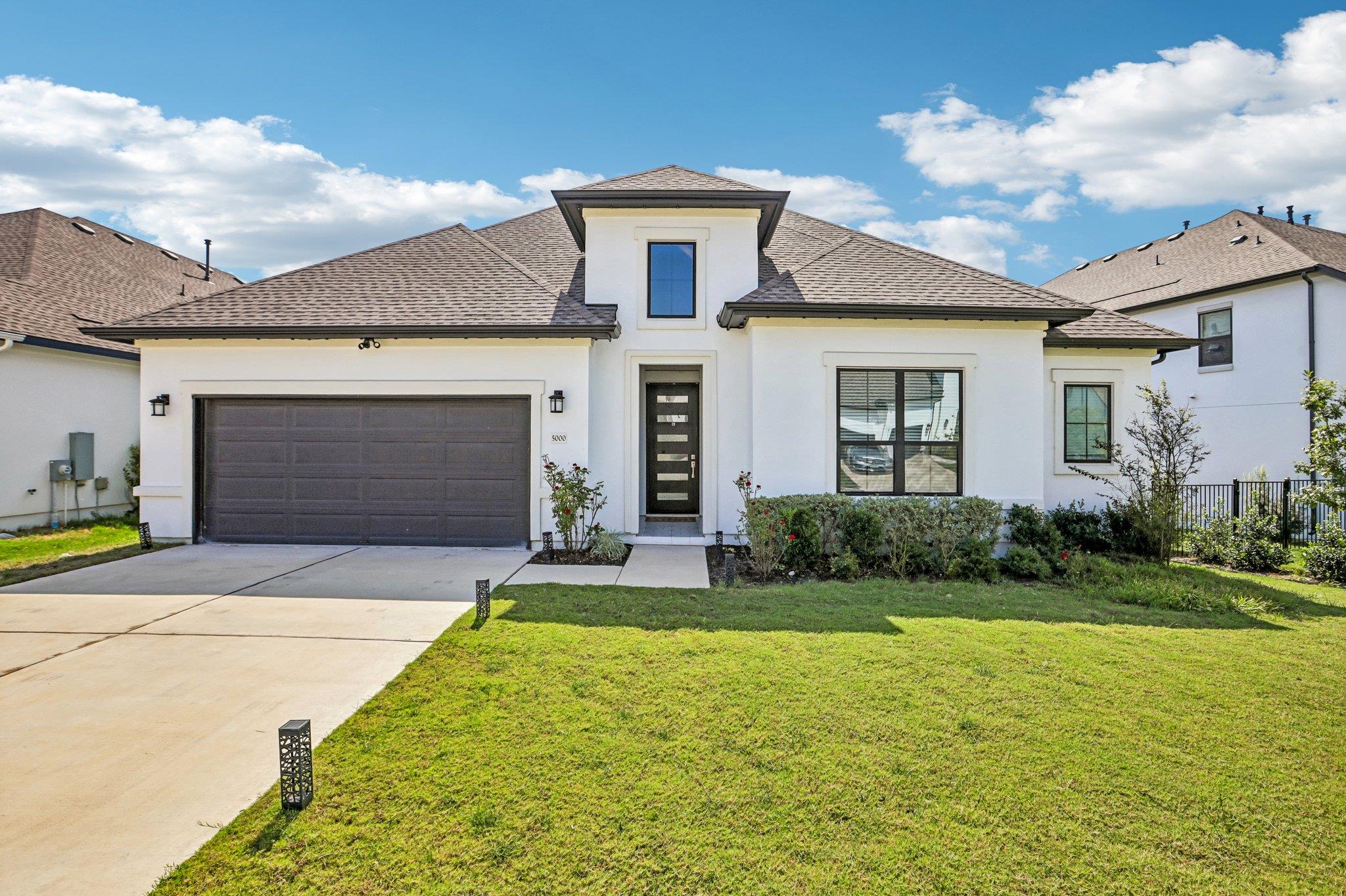 Crisp stucco siding paired with a dark shingle ro