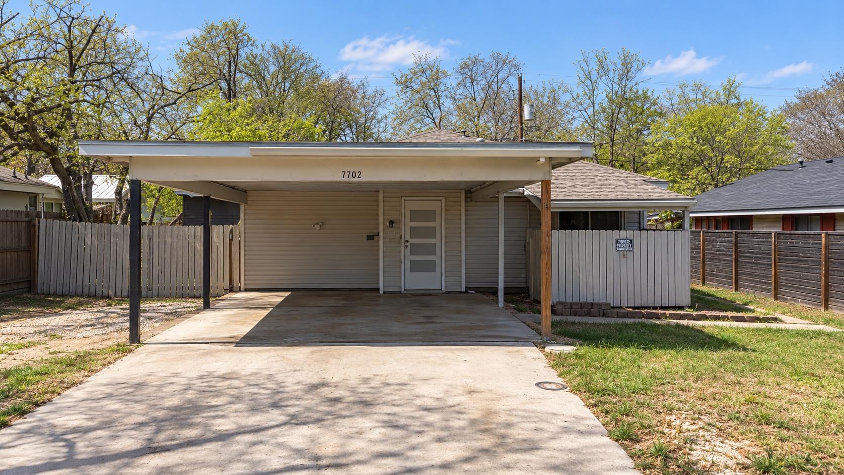 An attached carport and concrete driveway provide