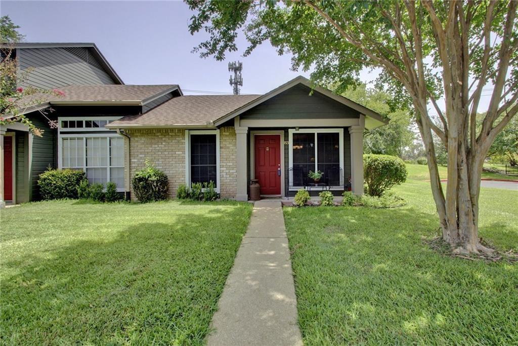 A concrete walkway leads past a grassy lawn to th