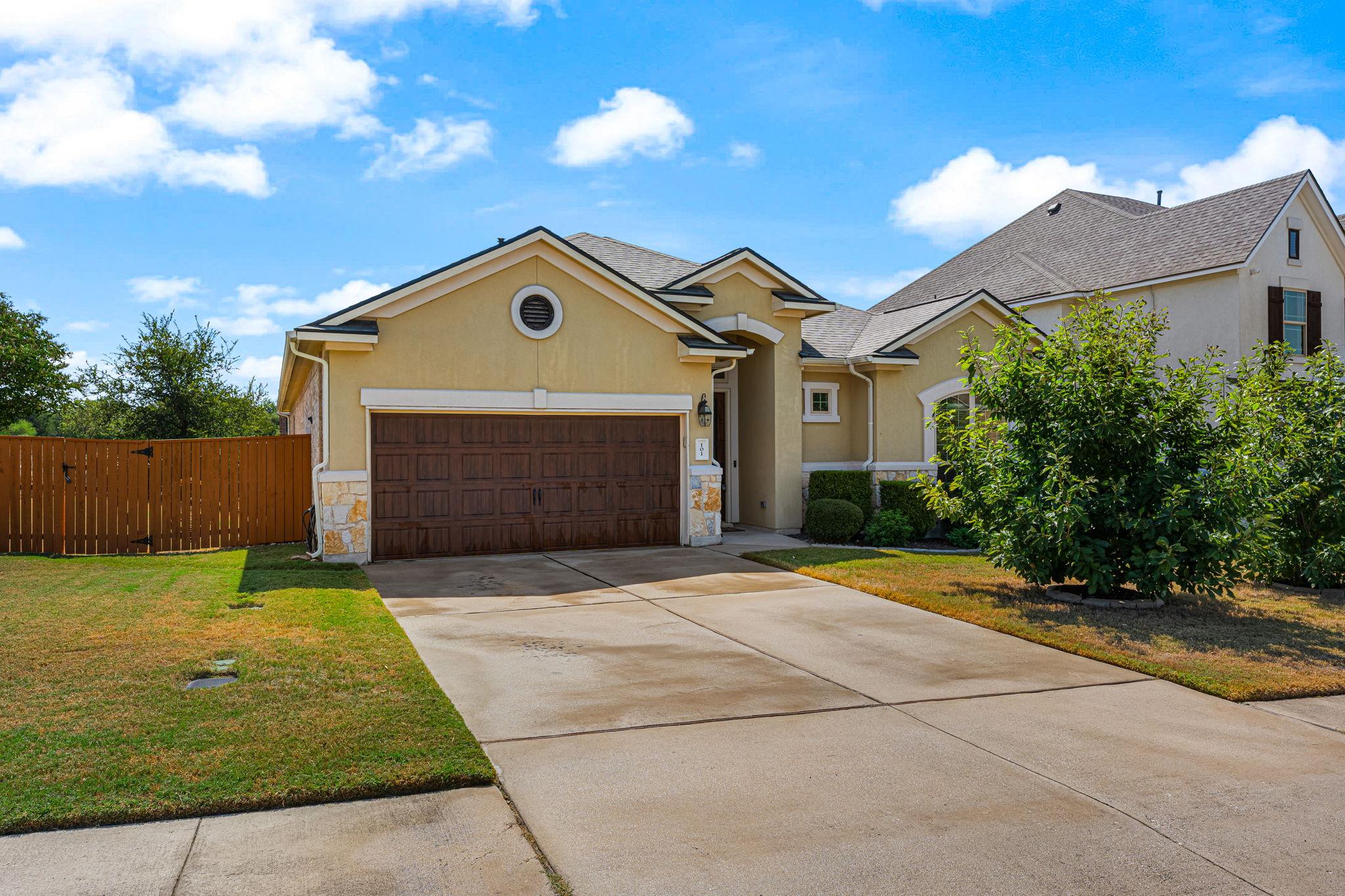 A spacious concrete driveway leads to the wood-to