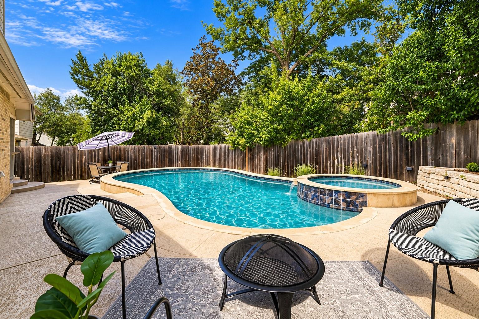 Lush mature trees border a private backyard pool 