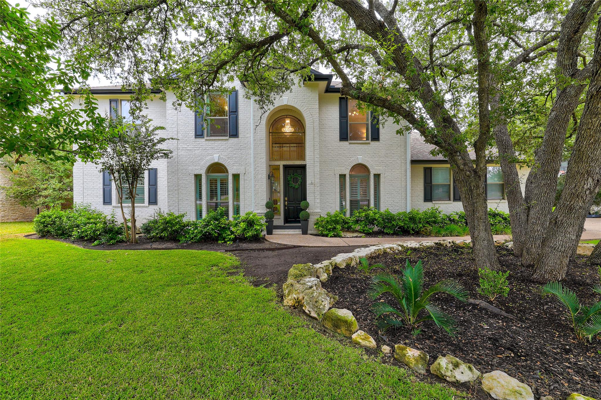Mature trees frame a classic brick exterior with 