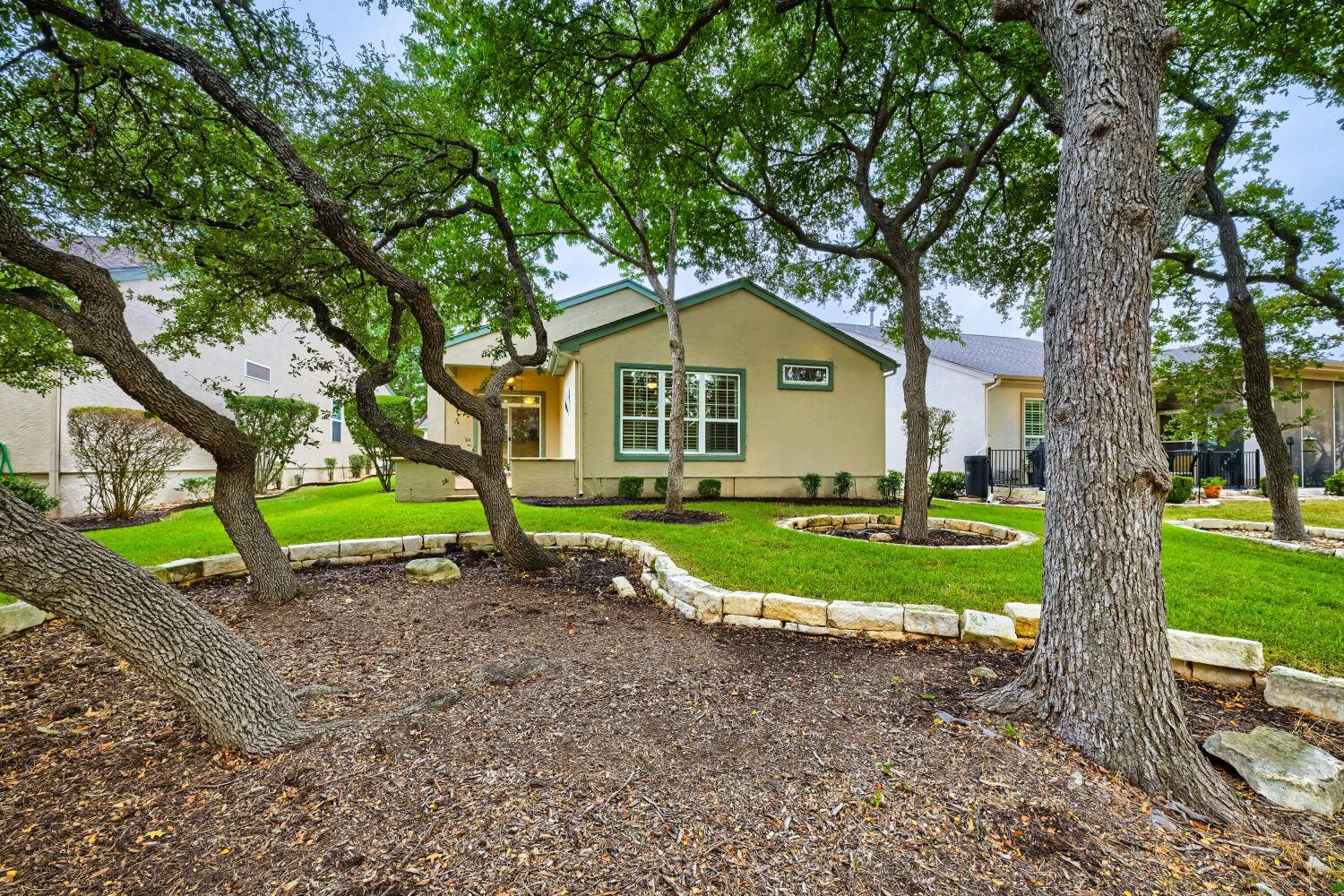 Mature shade trees and stone-bordered landscaping