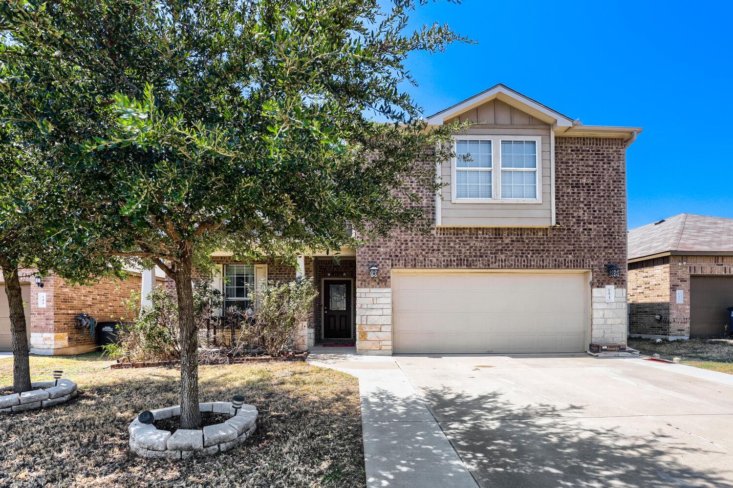 A classic brick exterior and concrete driveway fr