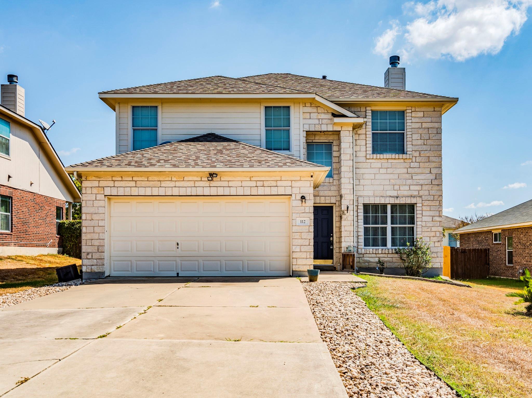 A spacious driveway leads to this two-story stone