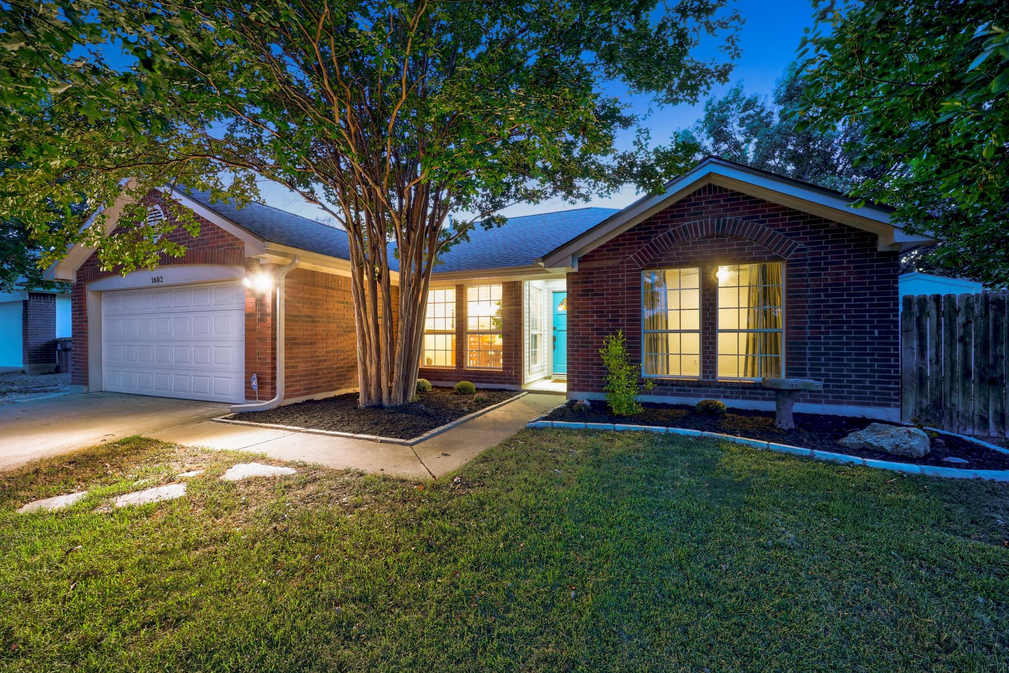 Mature trees shade the classic brick exterior of 