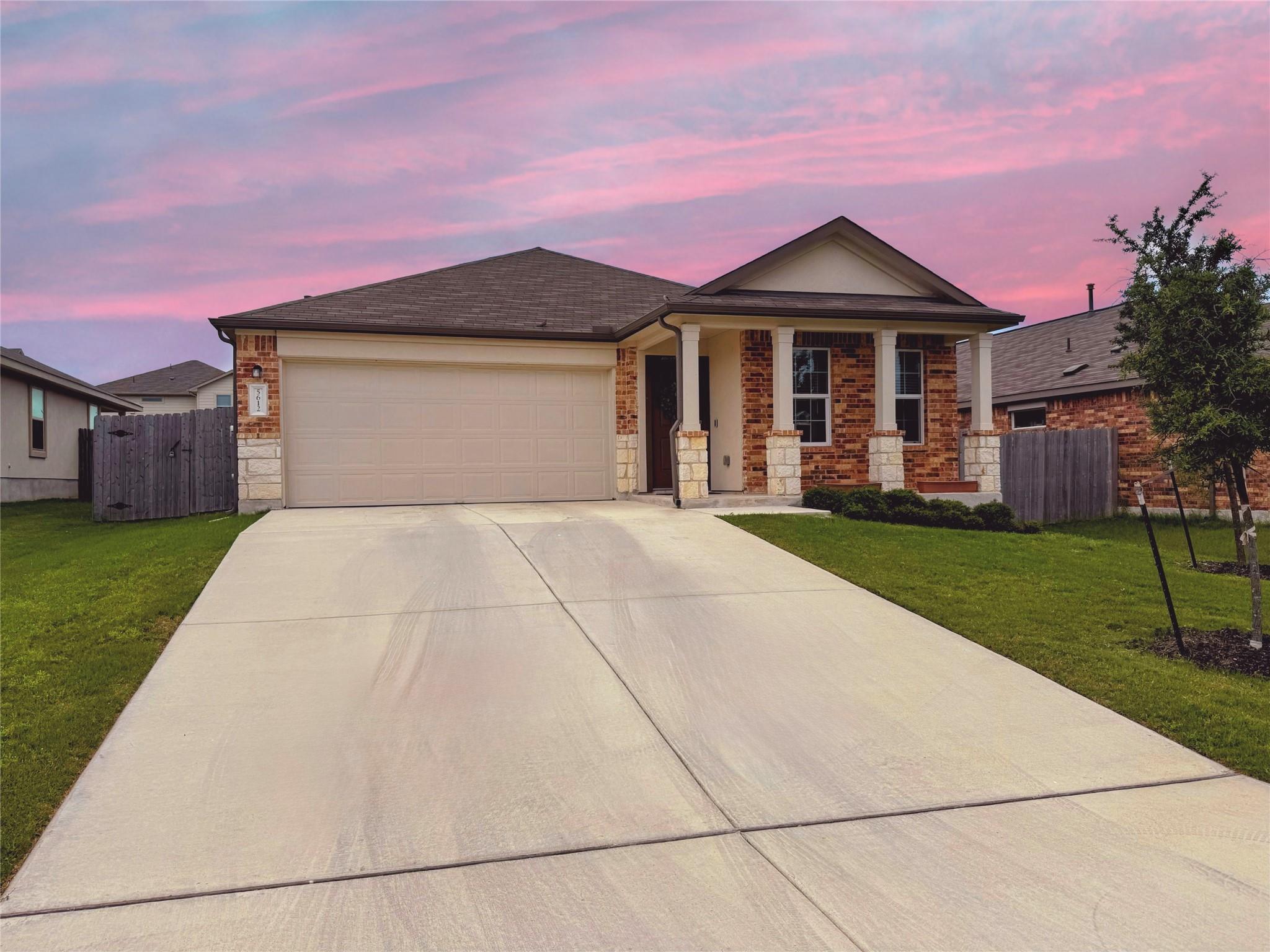 A spacious concrete driveway leads directly to th
