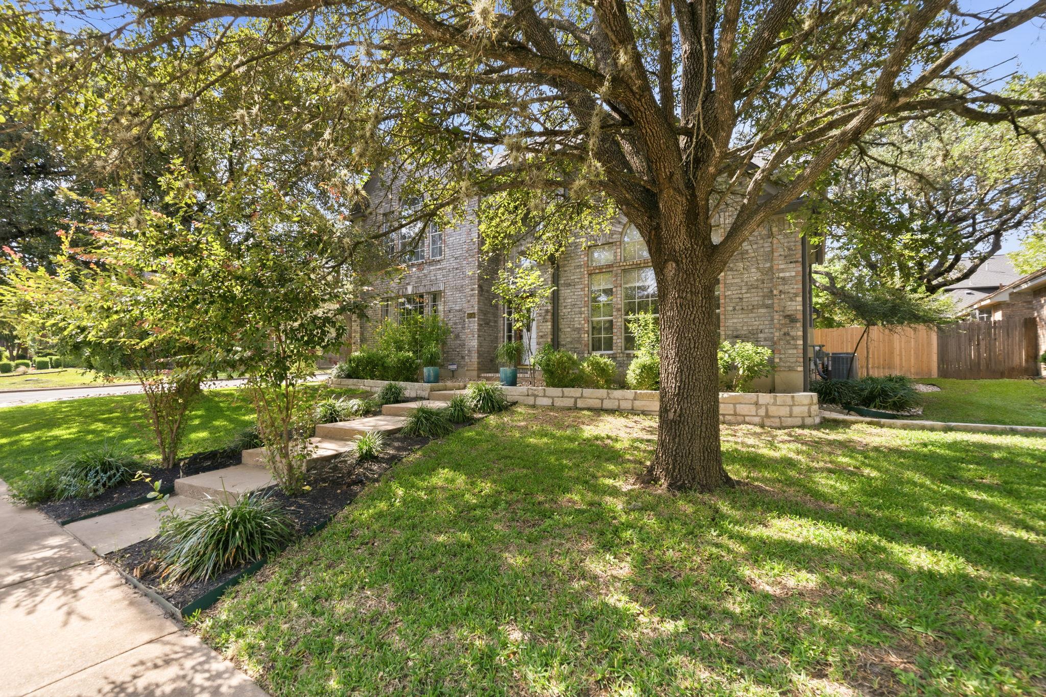 Mature trees shade the manicured lawn leading up 