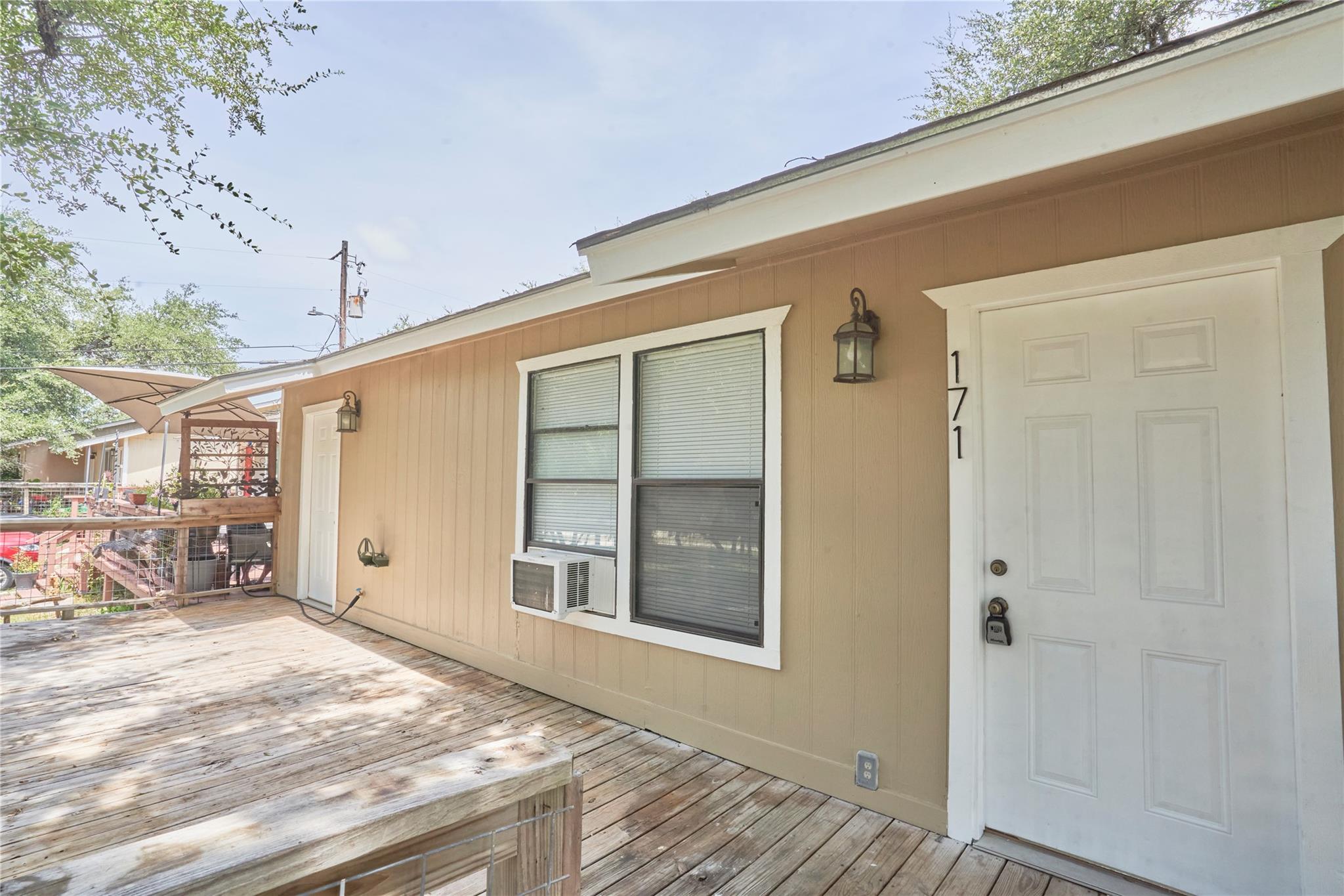 An inviting wooden deck connects the exterior ent