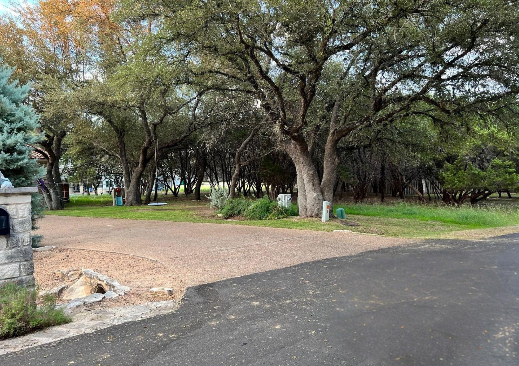 Mature shade trees frame the entrance to this pri
