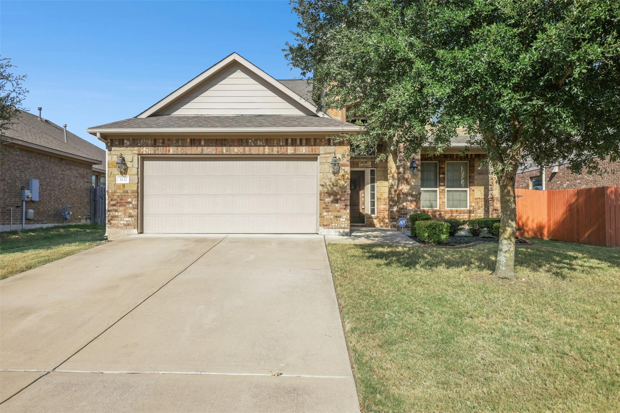 Classic brick accents and a manicured lawn define