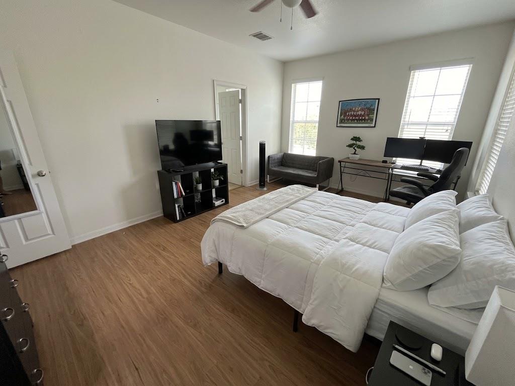 Warm wood flooring and multiple windows enhance t