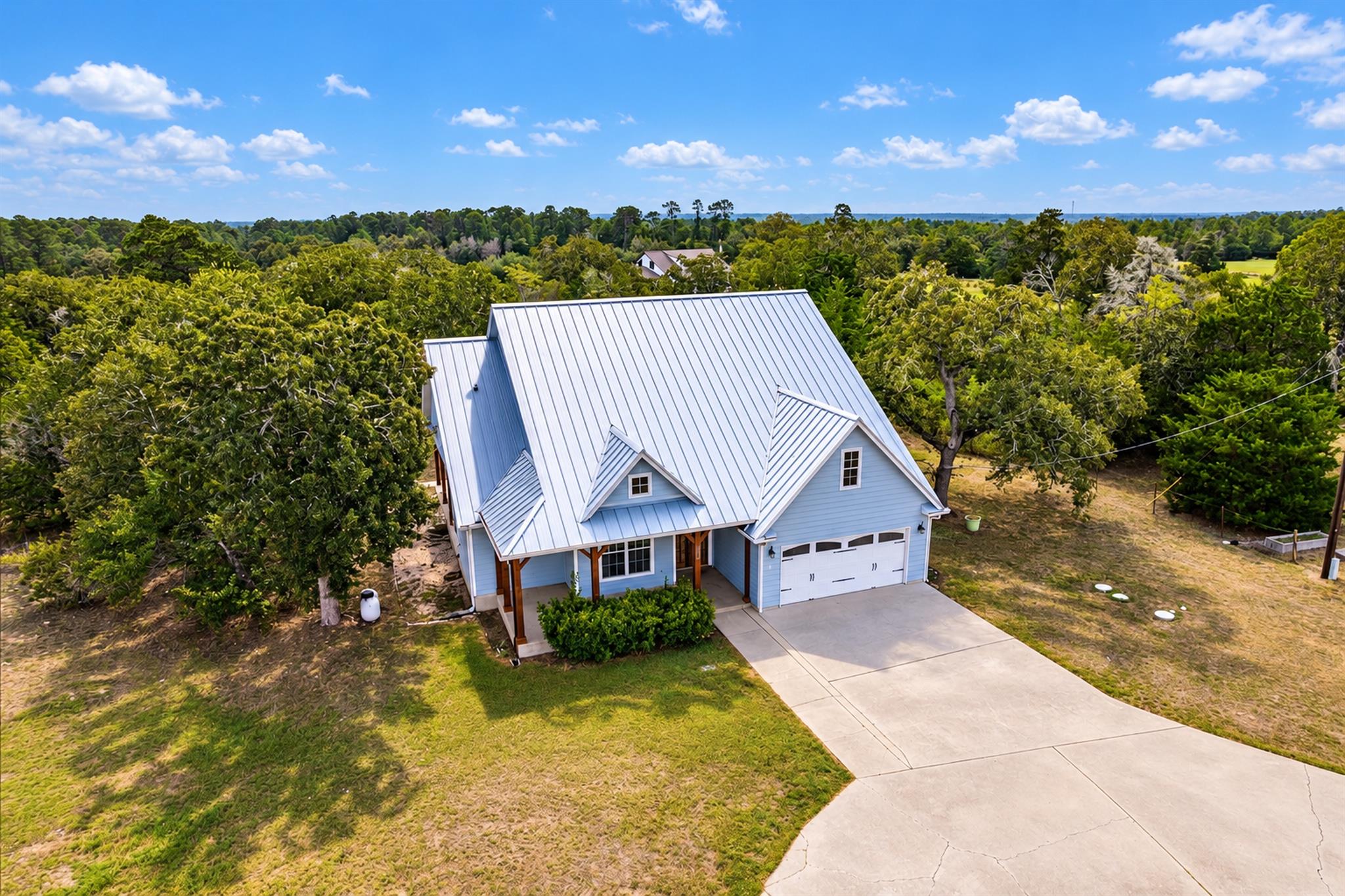 Mature trees frame a charming home featuring a du