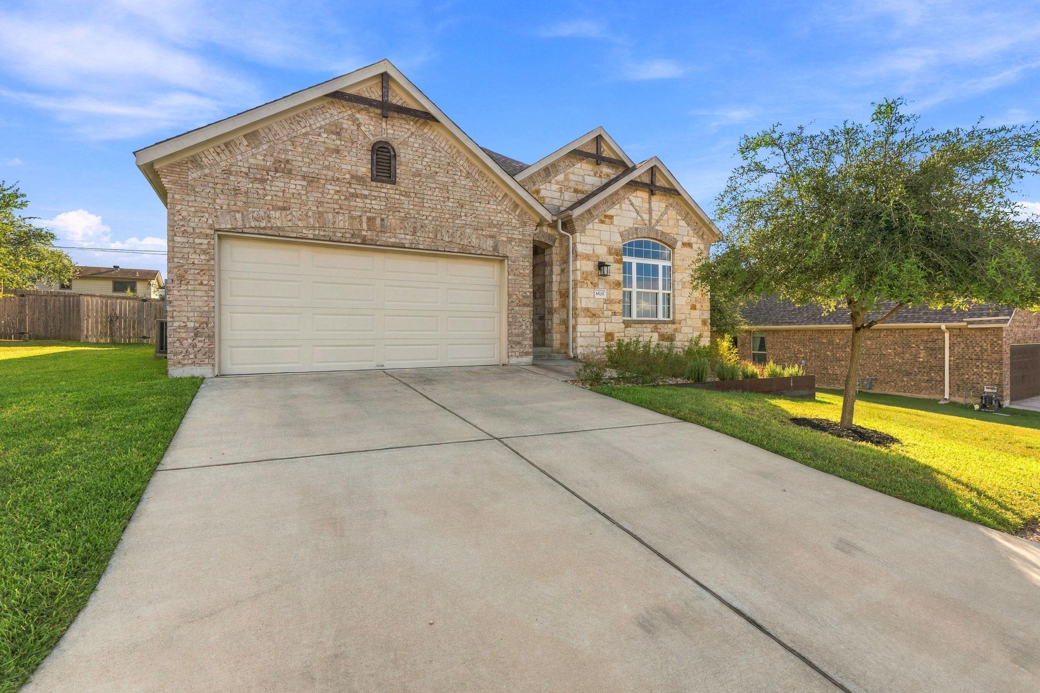 An inviting stone and brick exterior features a s