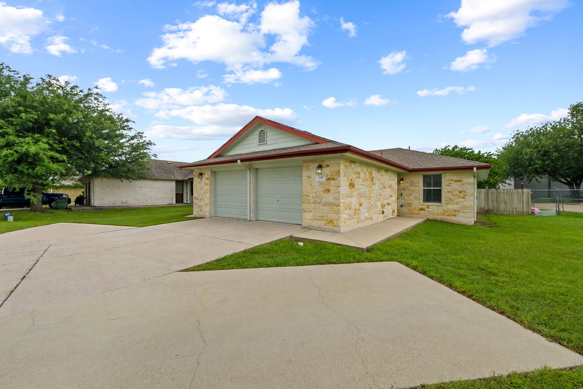 A spacious concrete driveway leads toward the cha