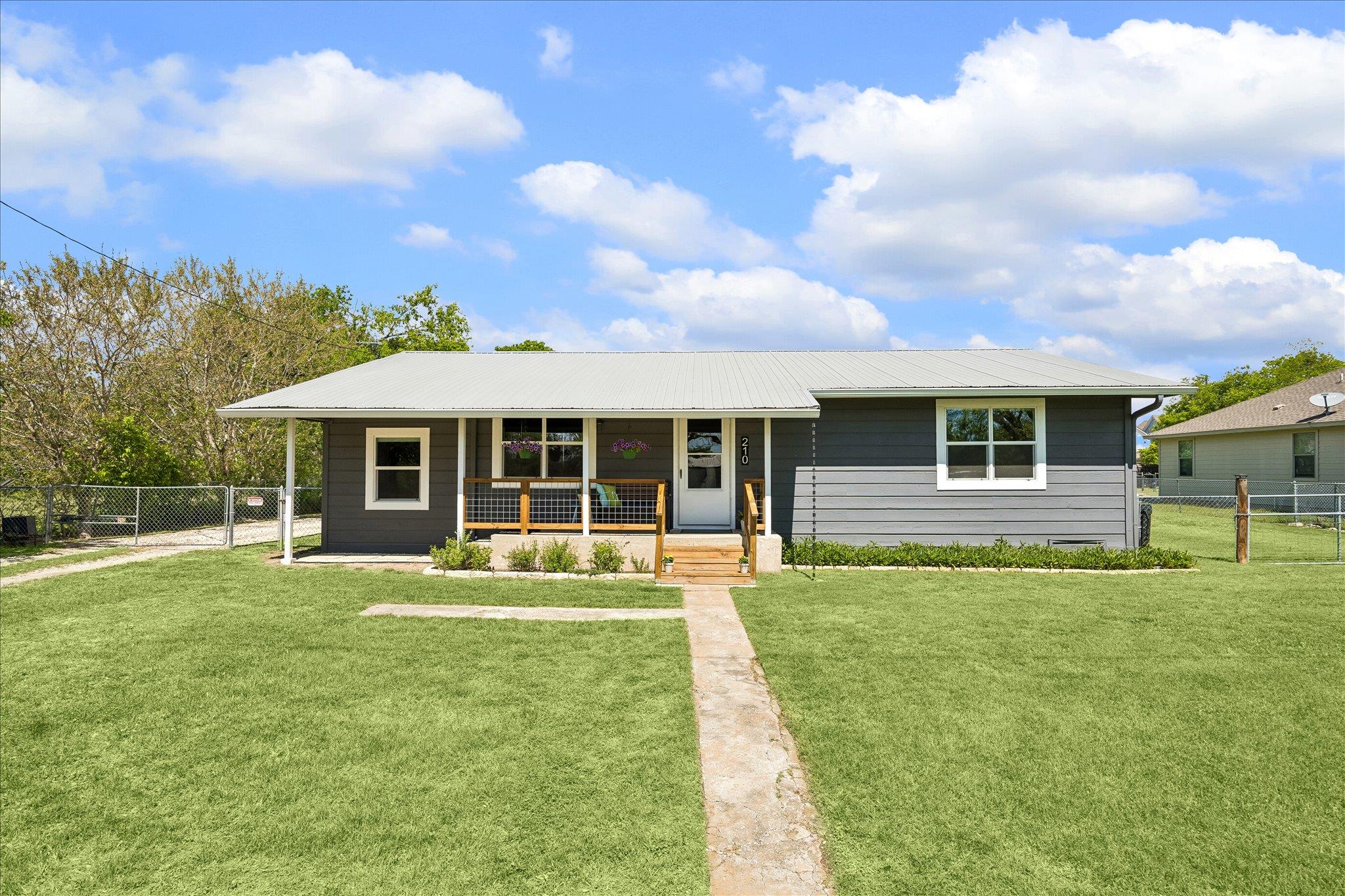 An inviting front porch and metal roof highlight 