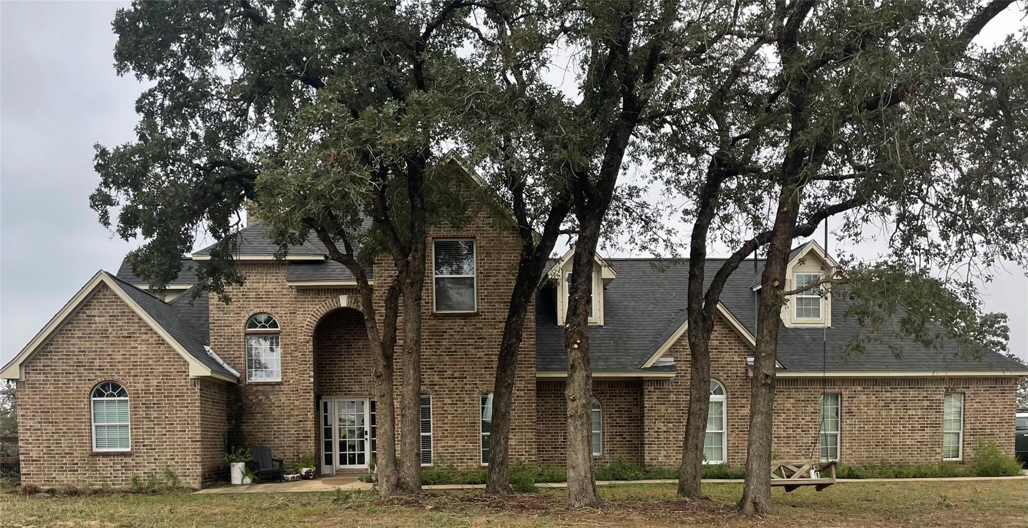 Mature trees shade a classic multi-story brick fa