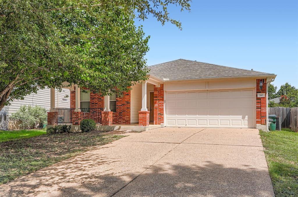 A spacious driveway leads to this charming brick 