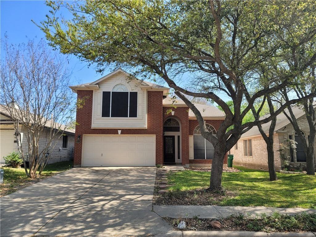 Mature trees shade a classic two-story brick exte