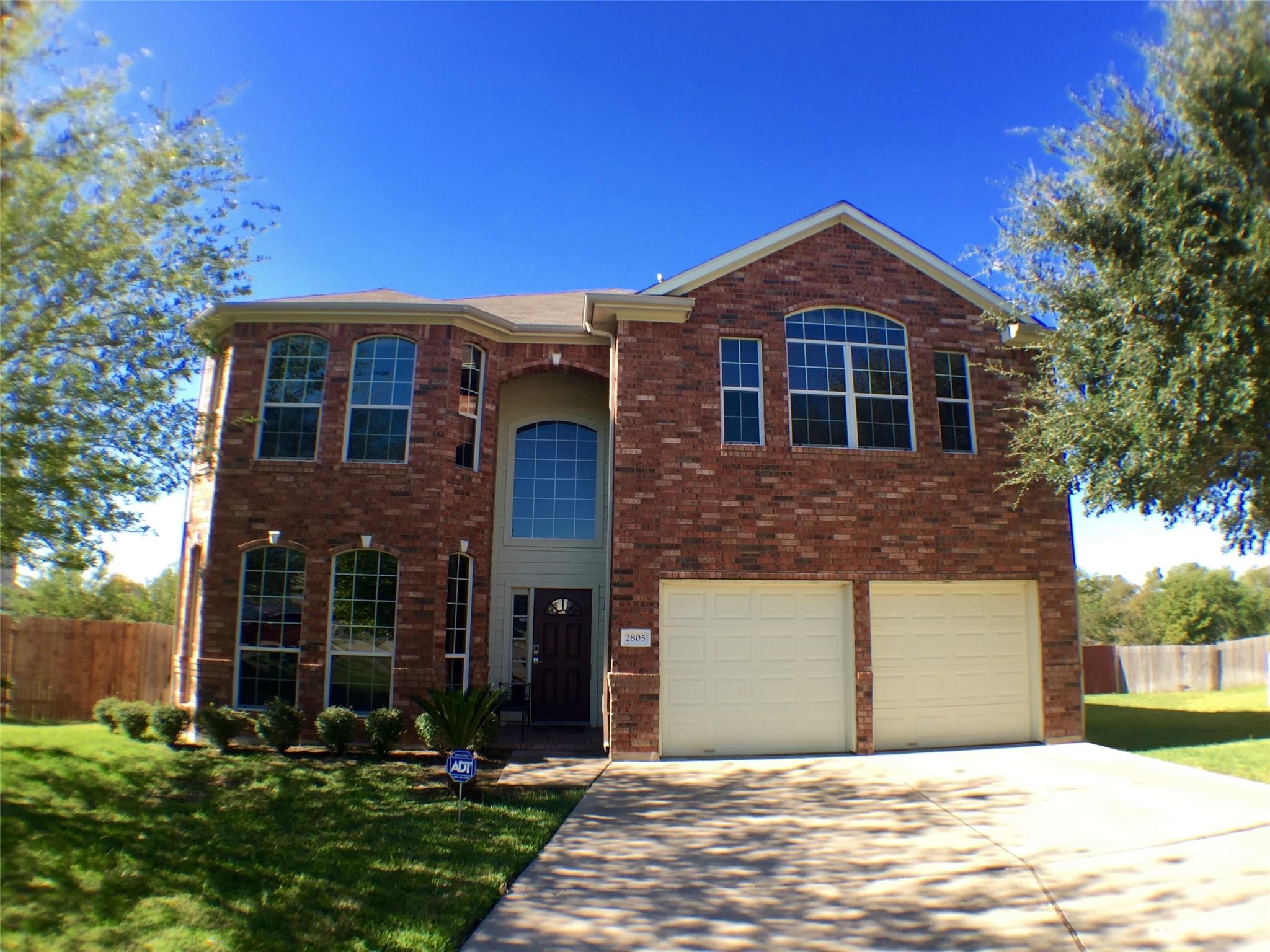 A classic brick exterior presents arched windows 