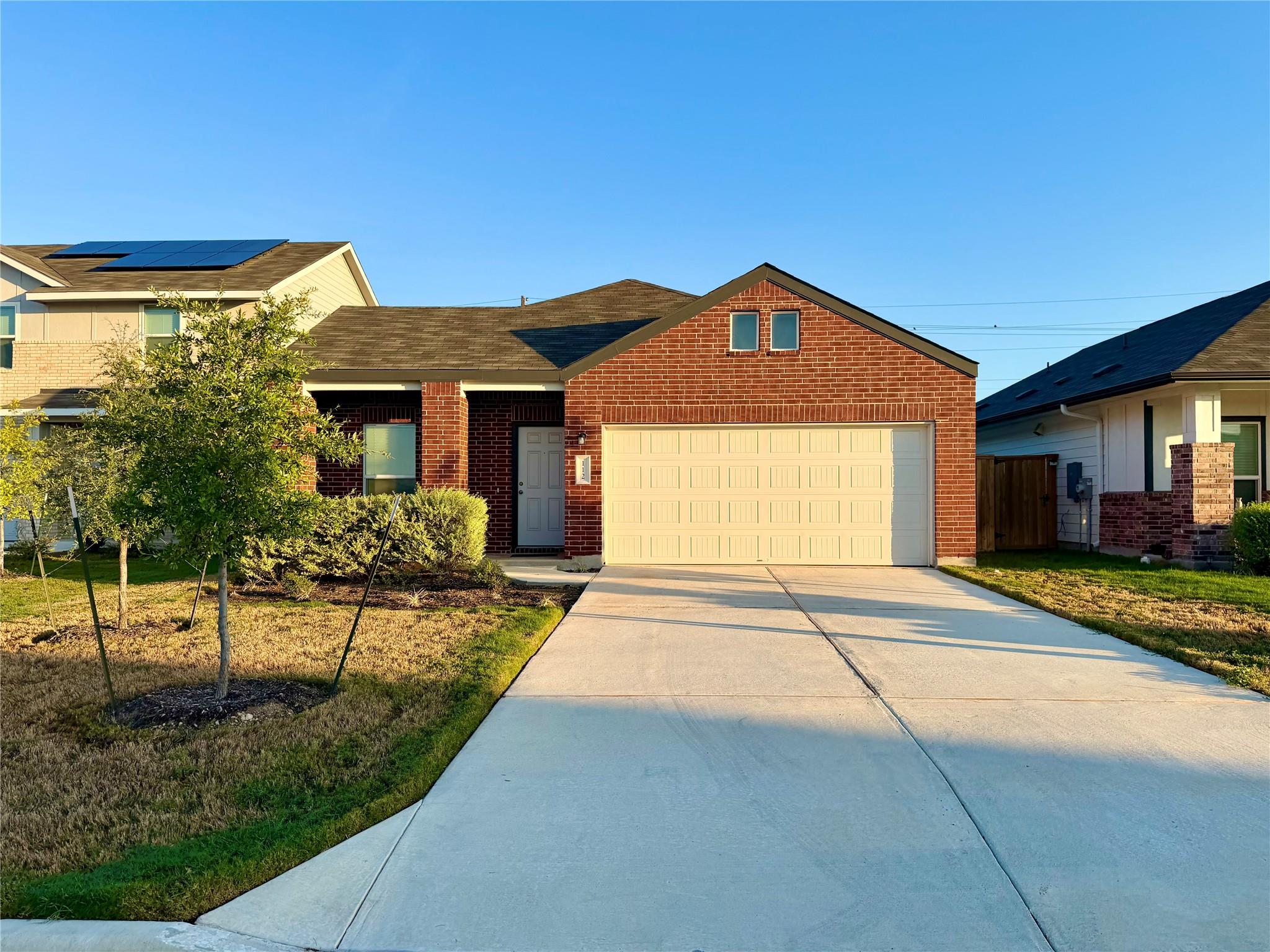 A wide concrete driveway leads to the two-car gar