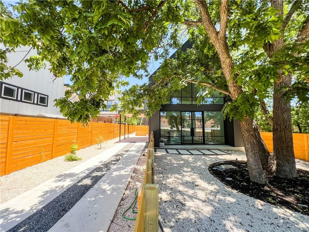 Mature trees shade a modern back exterior featuri