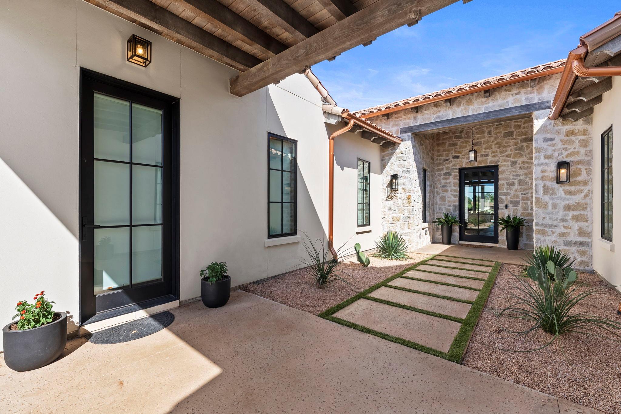 An inviting stone and stucco entryway leads past 