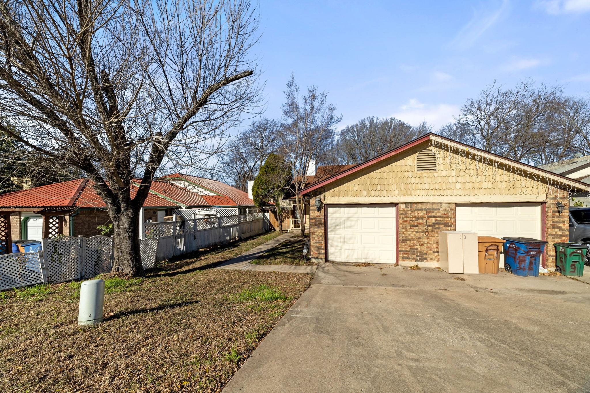 A wide concrete driveway leads directly to a clas
