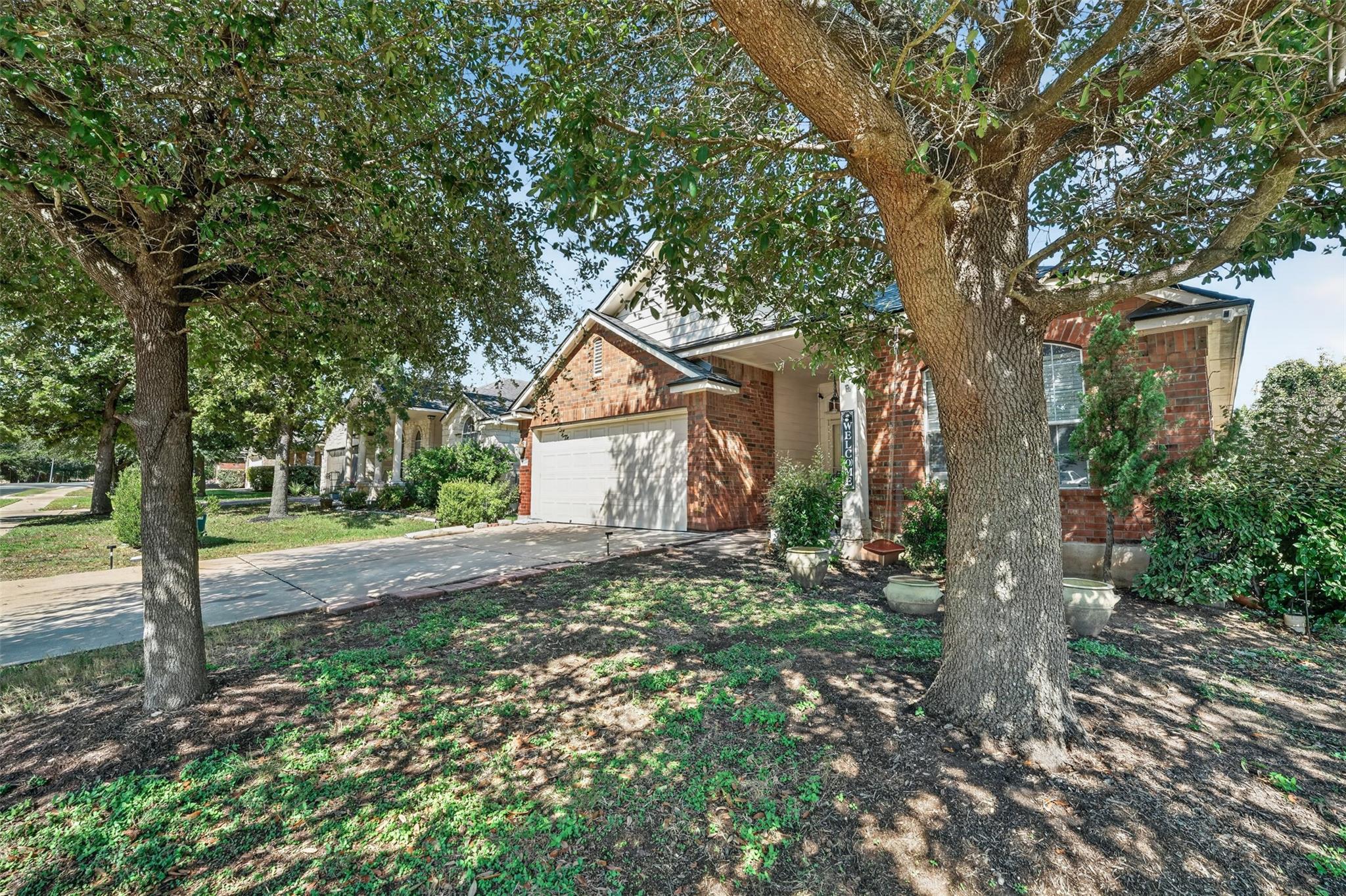 Mature shade trees frame the classic brick facade