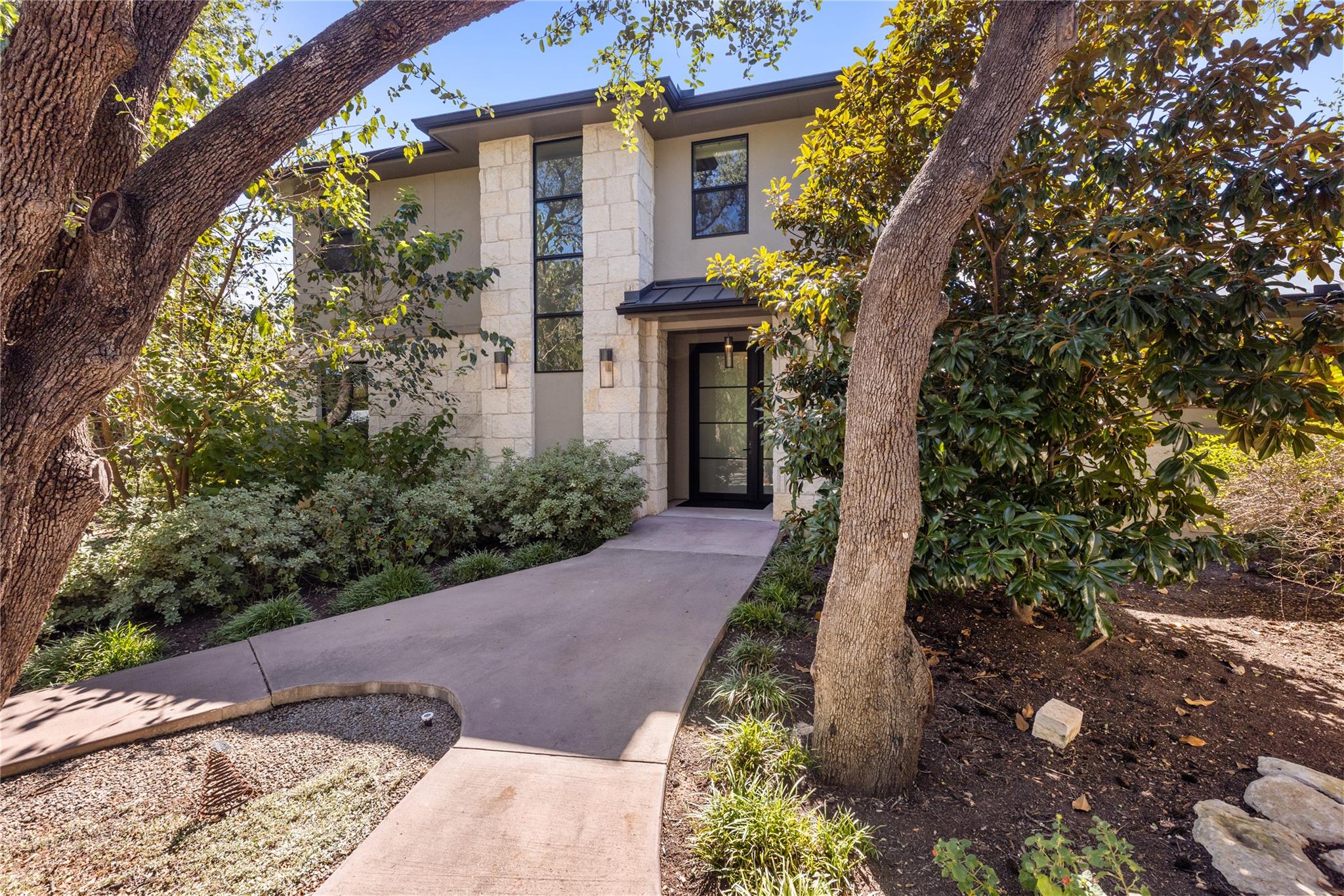 Mature trees frame a concrete pathway leading to 