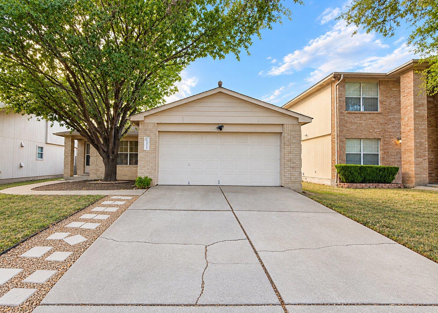 A spacious driveway leads directly to a front-loa