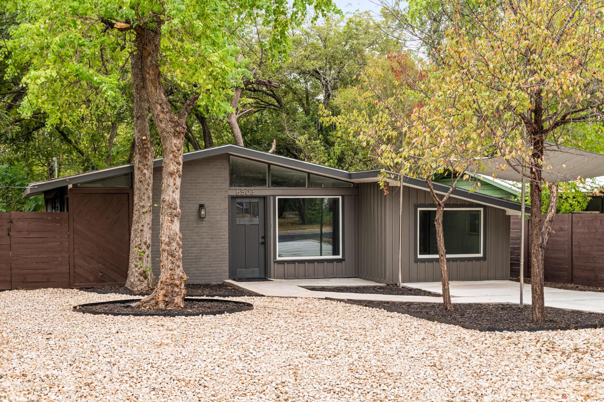 Mature trees frame a midcentury exterior featurin