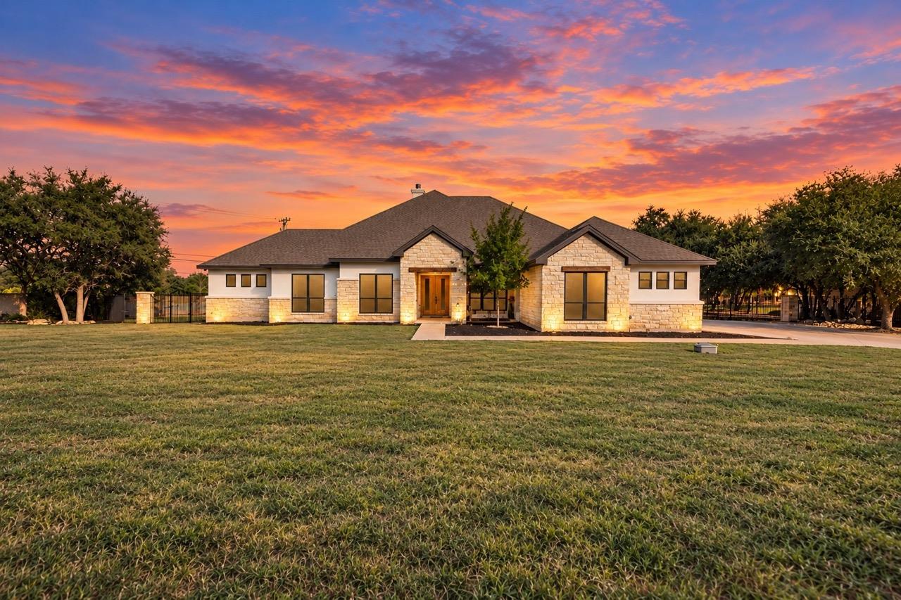 A spacious green lawn stretches before this moder