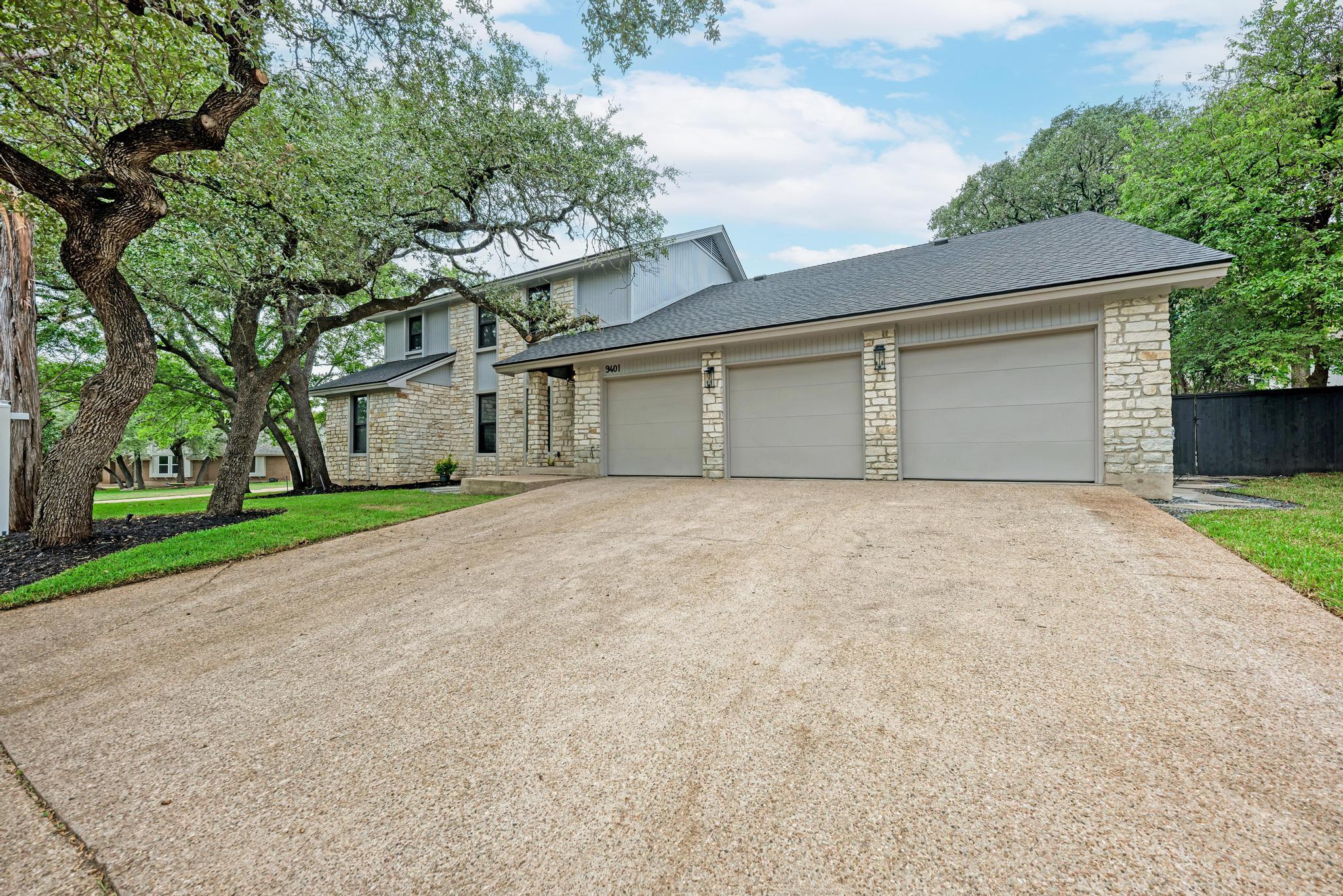 Mature shade trees and manicured landscaping surr