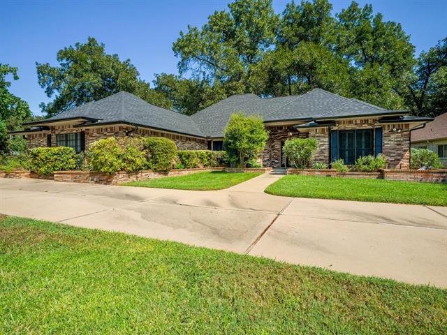 A spacious concrete driveway leads to this classi