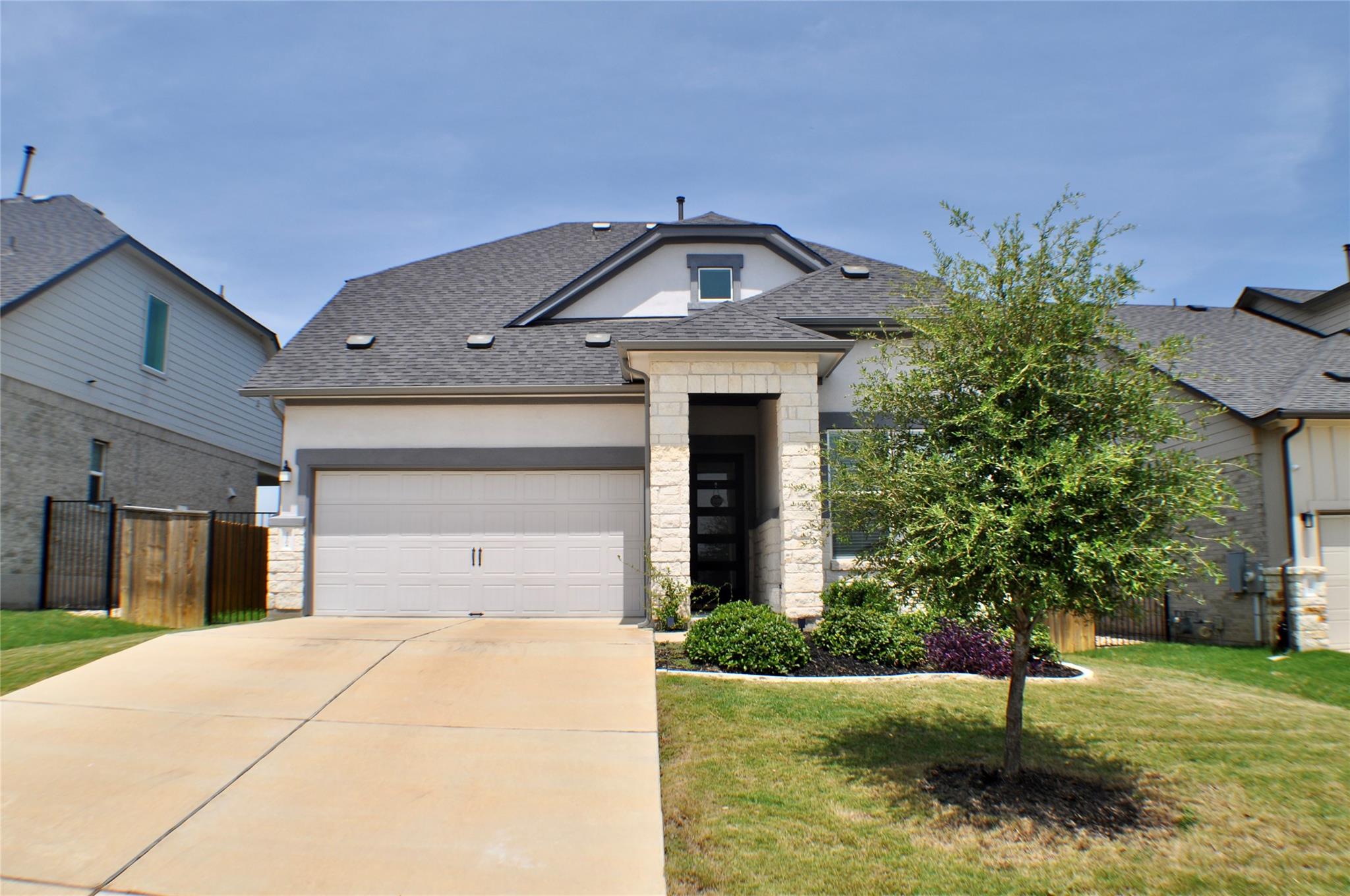 An inviting stone-accented entry and a neat concr