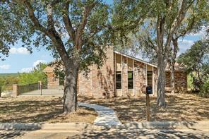 Mature oak trees frame a timeless brick facade fe