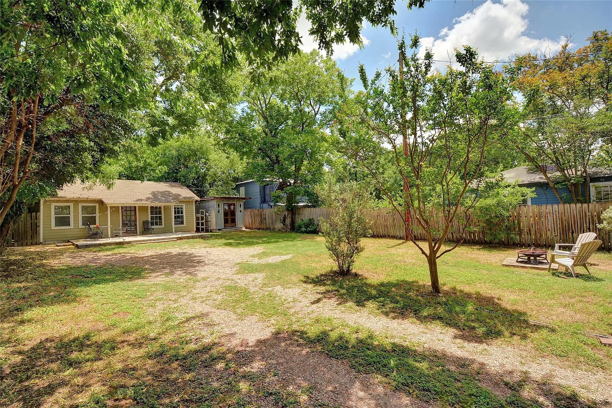 Mature trees shade a spacious lawn bounded by a w