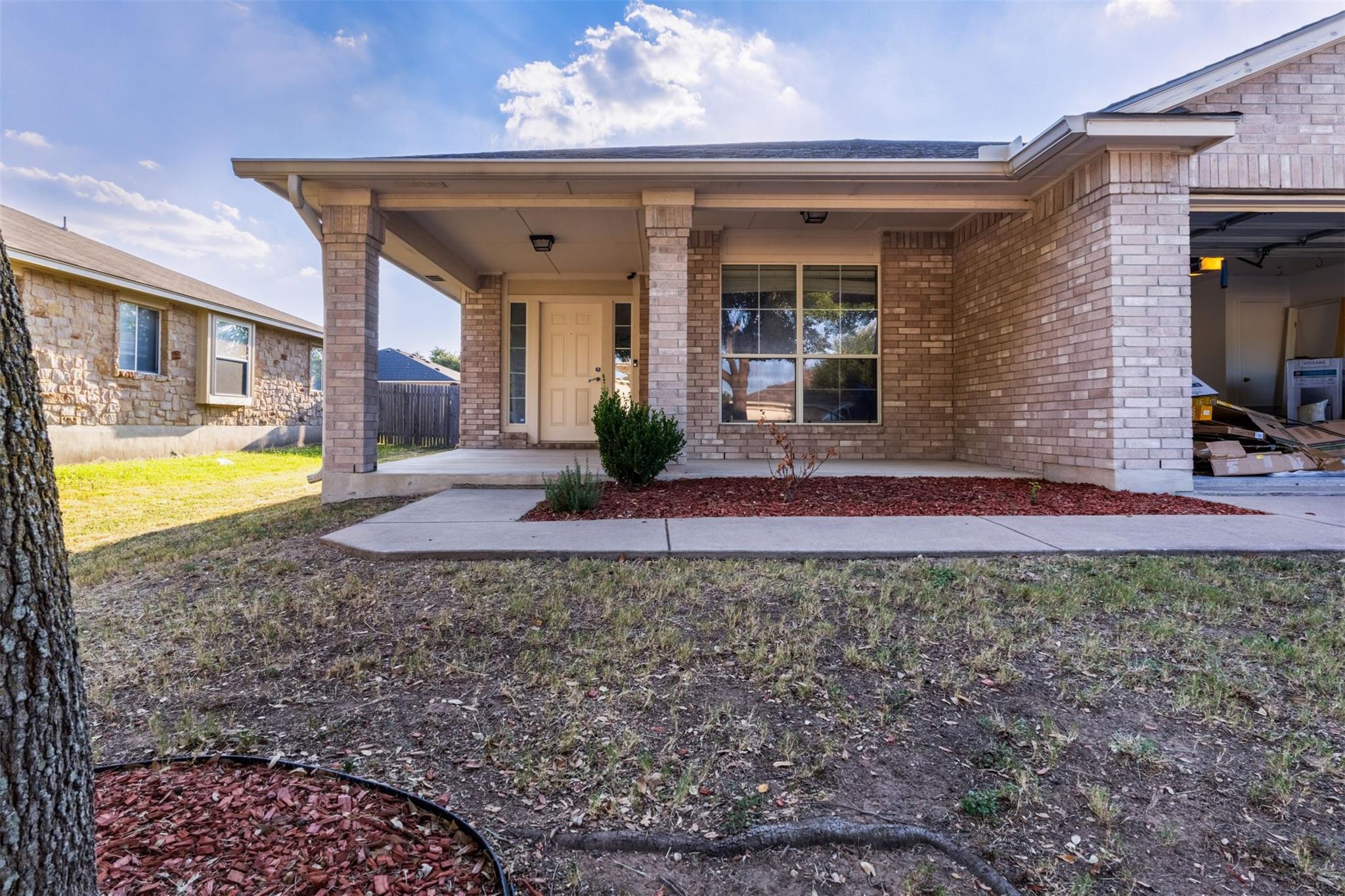 Brick pillars frame a covered front porch leading