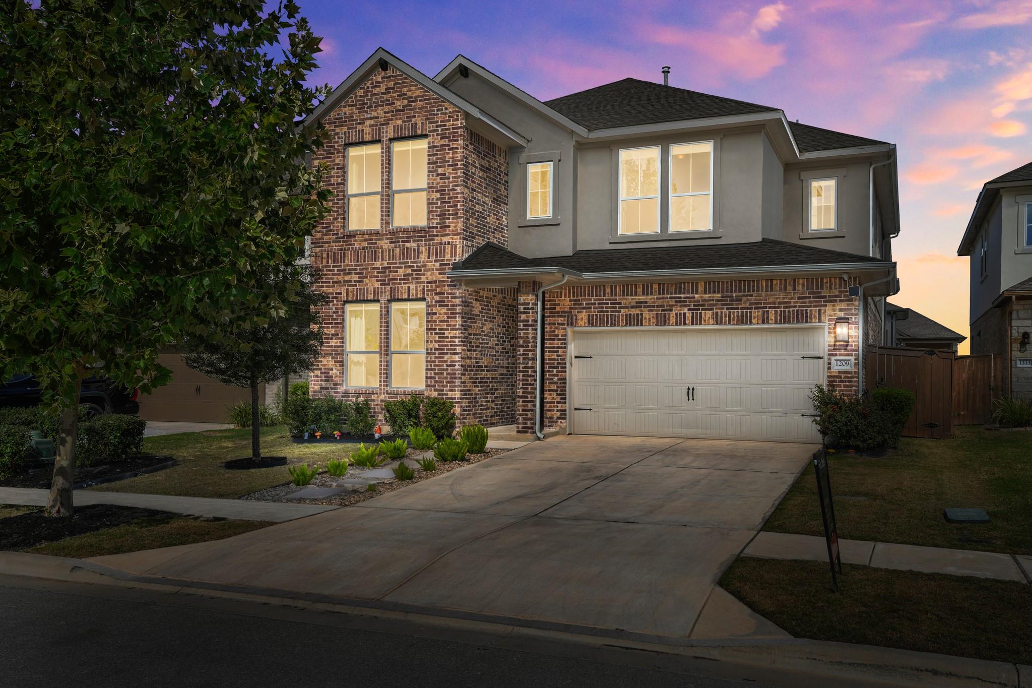 Two-story brick and stucco exterior features a sp